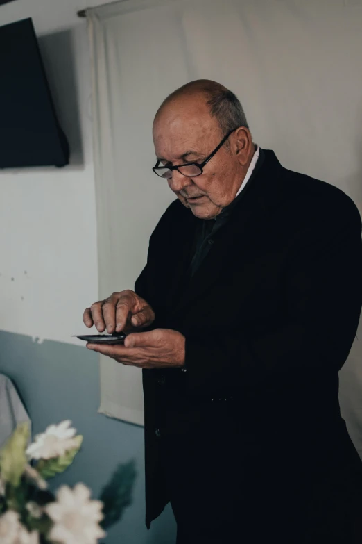 a man in black coat looking at his phone