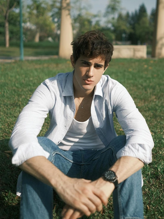 a young man sitting in a grassy area