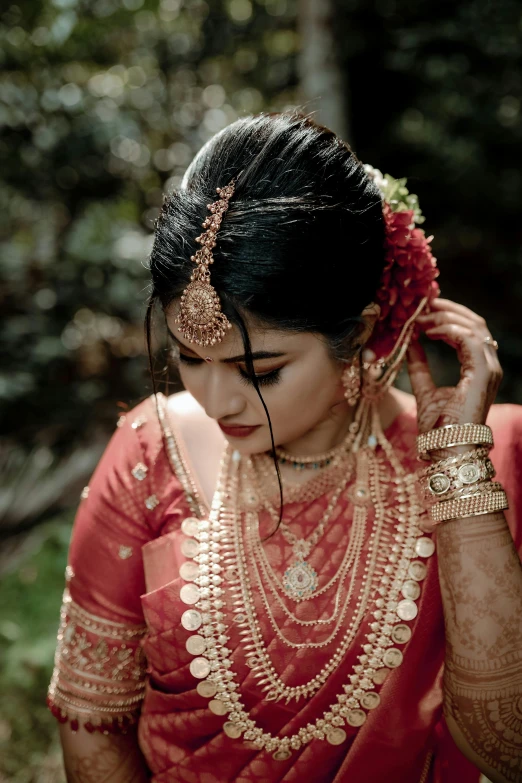 a beautiful woman in traditional indian dress looking down at her head