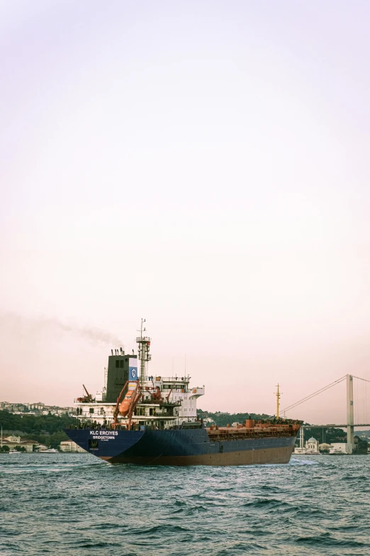 large blue boat in the ocean with smoke billowing out