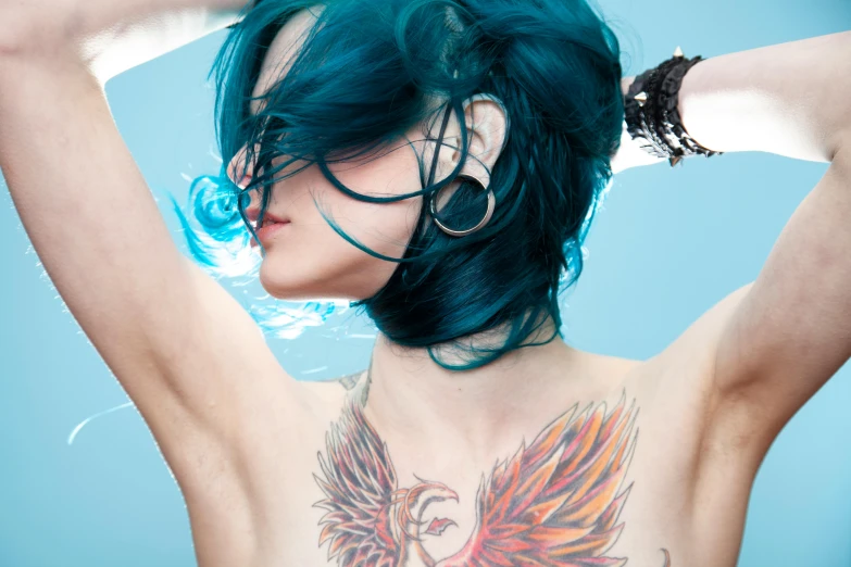 a woman with a huge tattoo on her back and blue hair