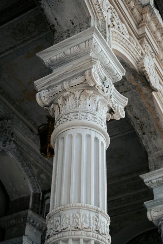 a tall, intricate white column is positioned between two walls