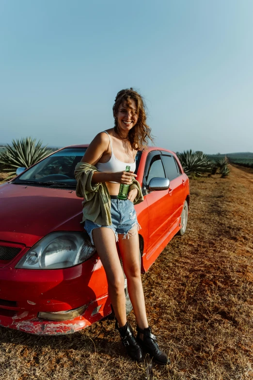 a woman posing next to a parked car