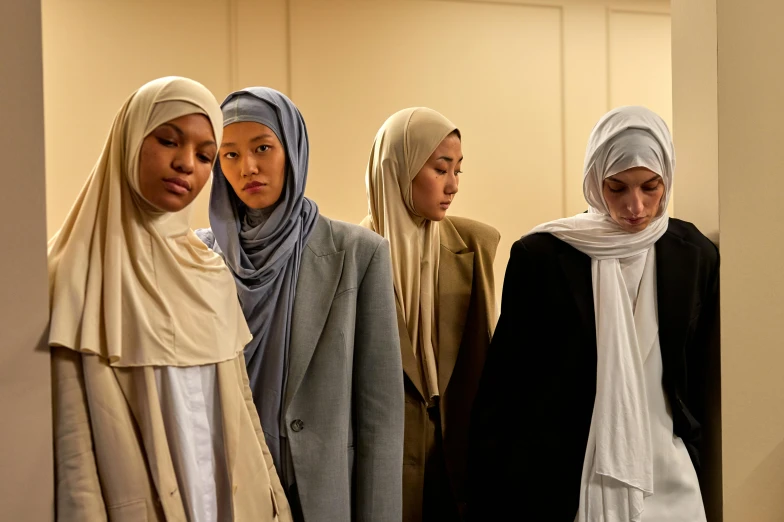 seven women in hijabs stand in a row