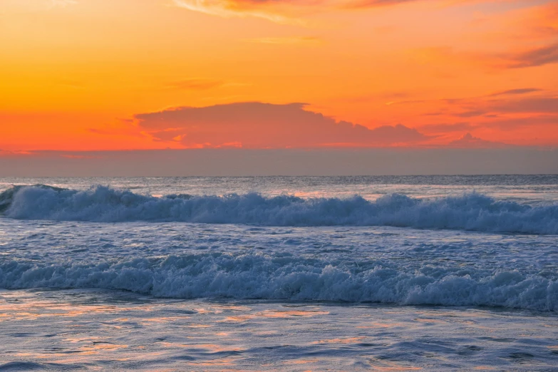 an orange, pink, and purple sunrise over the ocean