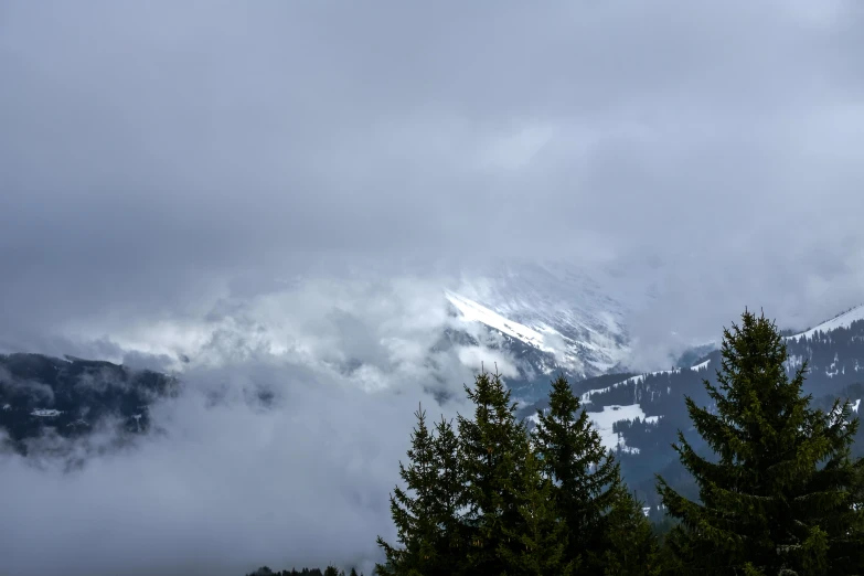 some mountains are covered in clouds and trees