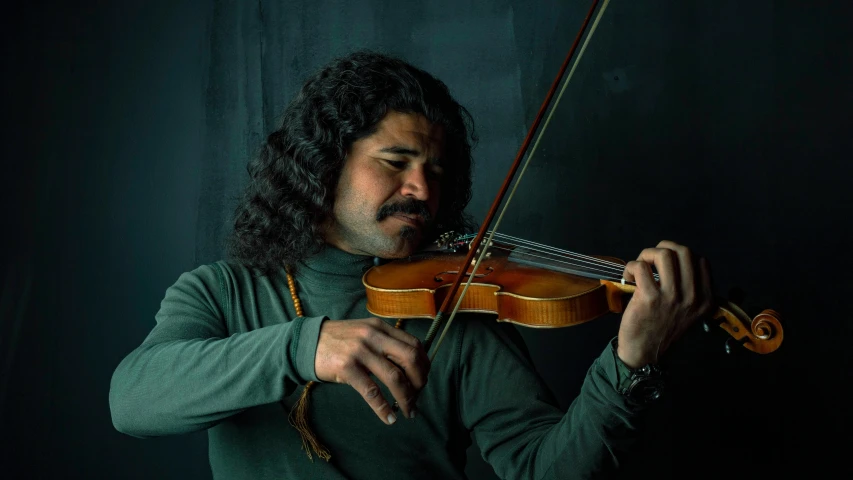 a man holding a violin in his right hand