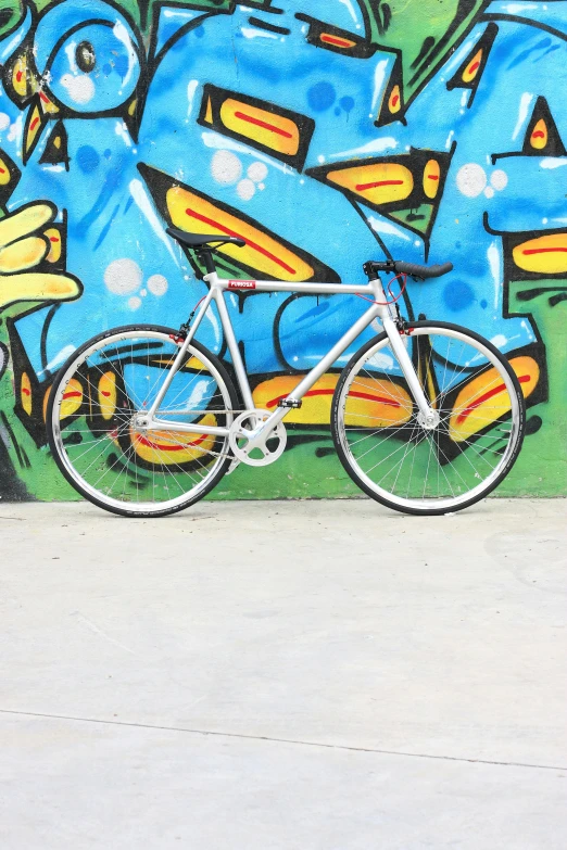 a bicycle parked against a graffiti covered wall