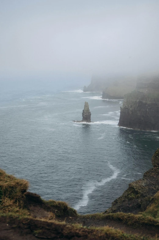 the rocky coastline with small green cliffs at each end