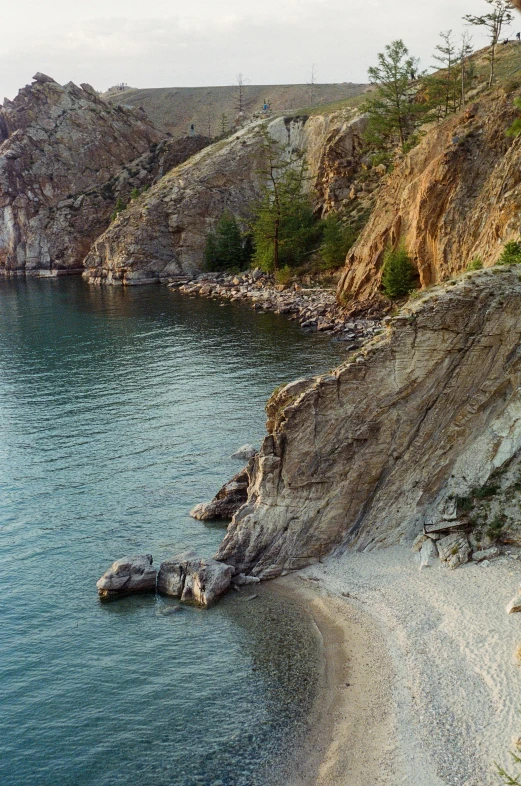 an uncoolured cliff and beach near a lake