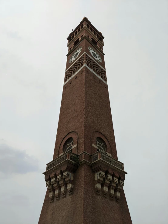 a tall brown clock tower with the tops half covered by a white clock