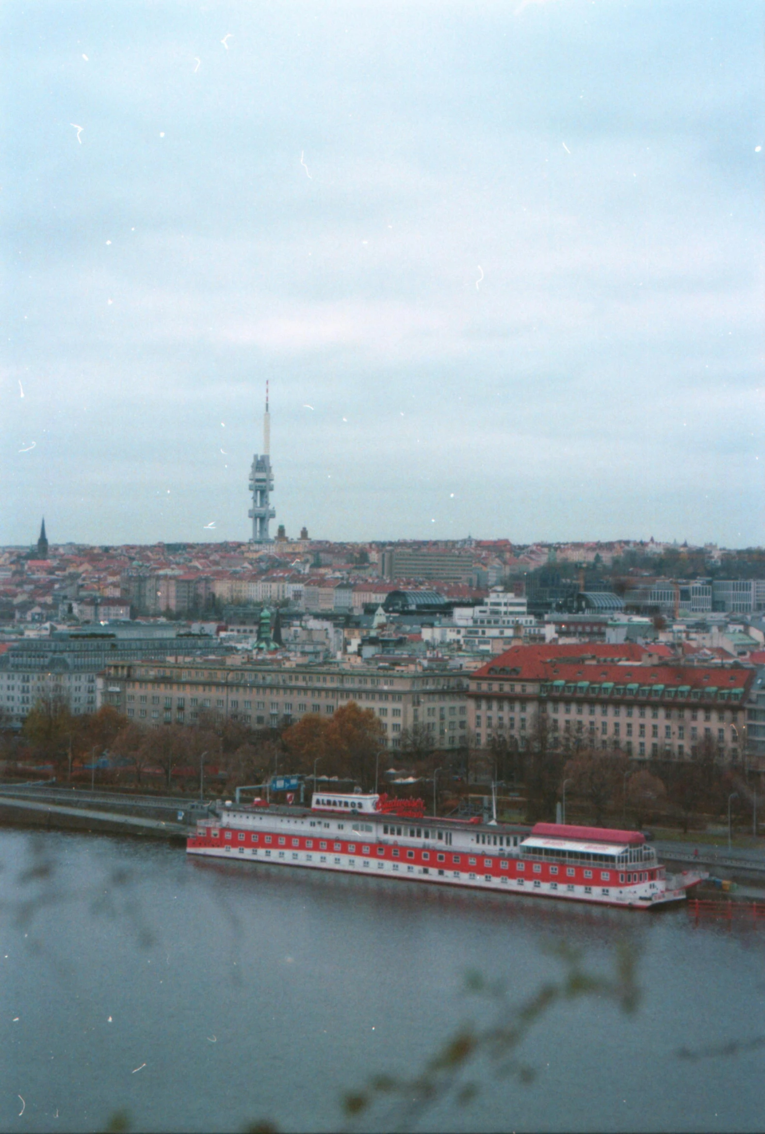 a river boat traveling past a city filled with buildings