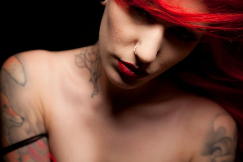 the woman has red hair and tattoos on her body