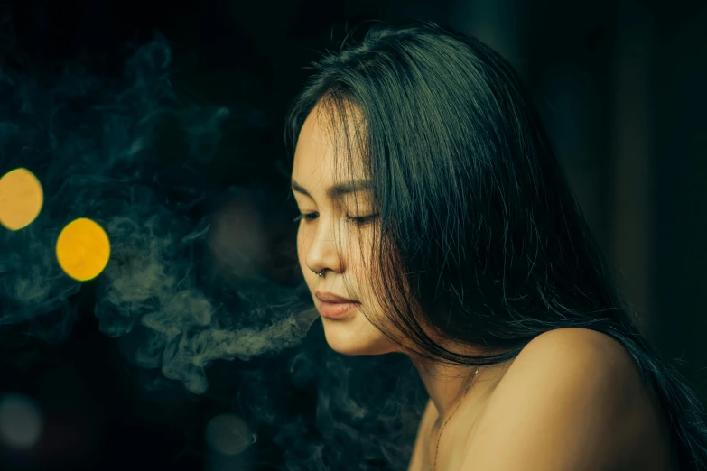 a woman stares into her camera with smoke rising behind her