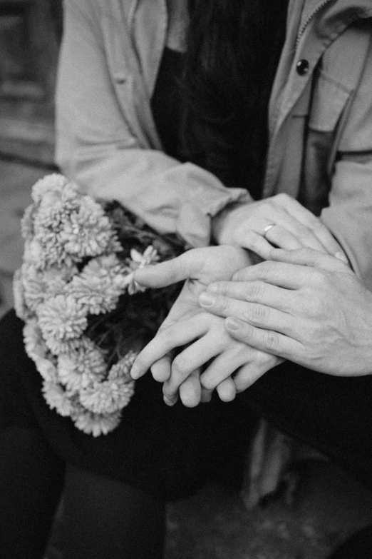 black and white image of a couple holding flower in their hands