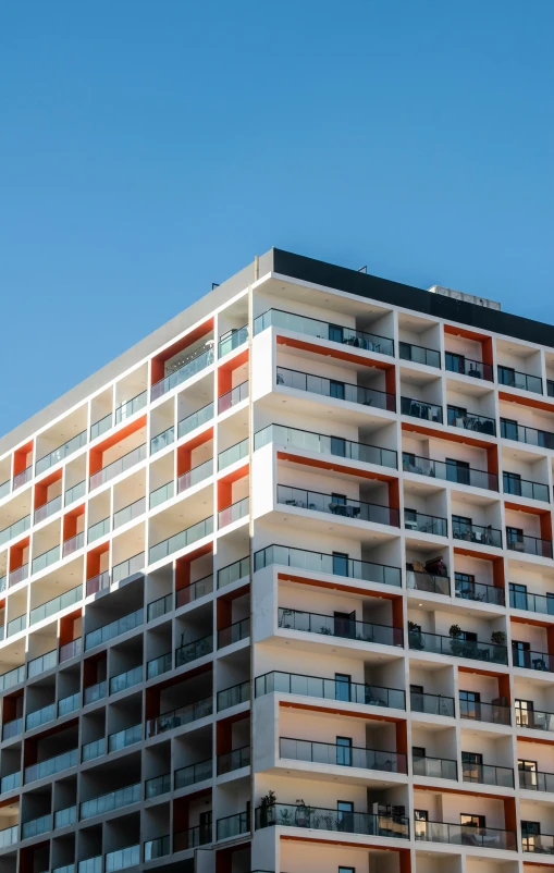 an orange and white apartment building against a blue sky