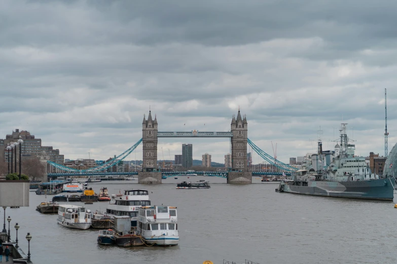 the boats are docked in the harbor by the tower bridge