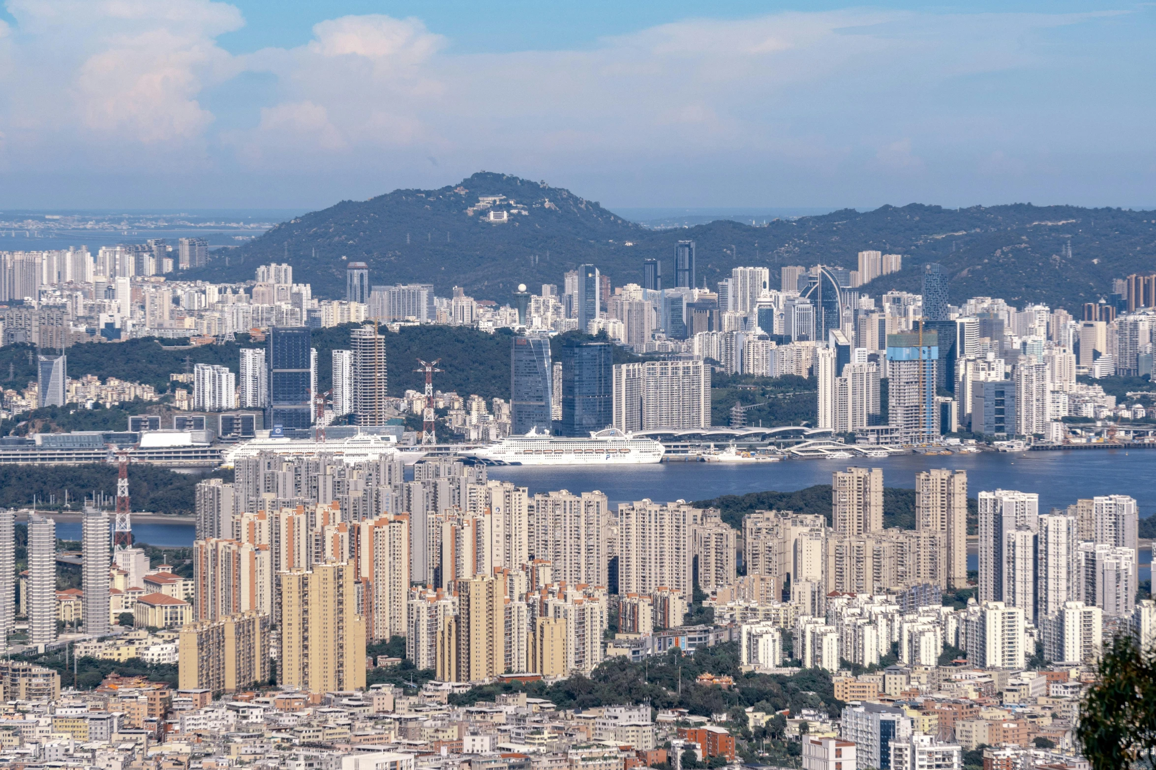 a large city with tall buildings, mountains and river