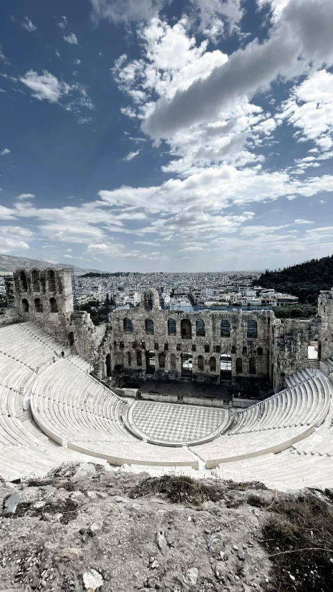 an empty, stone - walled theatre is seen against the sky