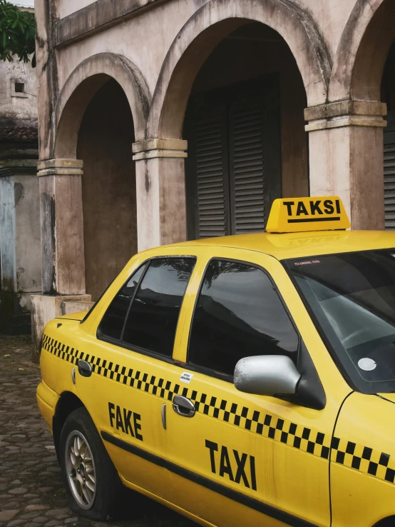 a yellow taxi cab parked in front of a building