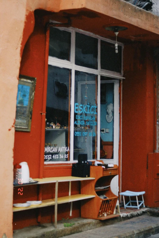 outside view of restaurant with a wooden table and orange wall