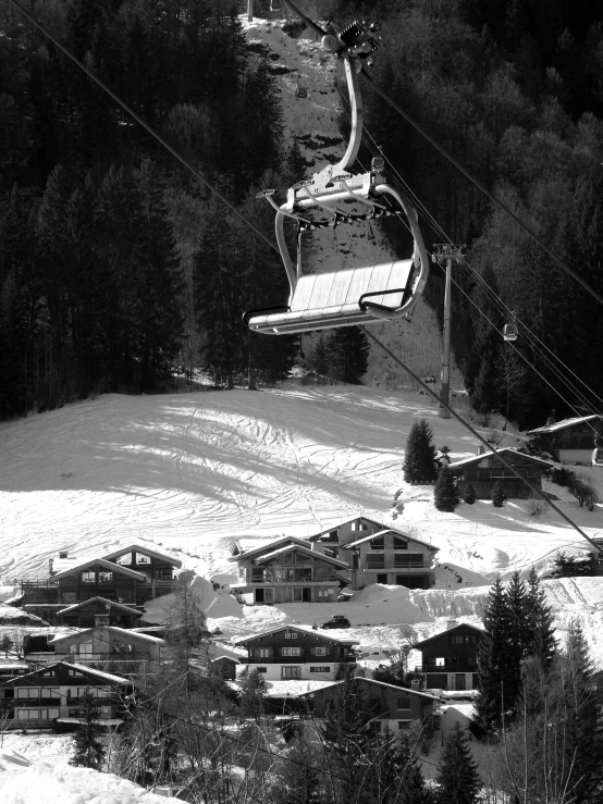 a ski lift going over a hill near buildings