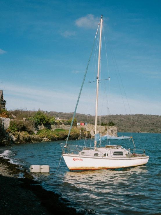 the white boat floats on the body of water