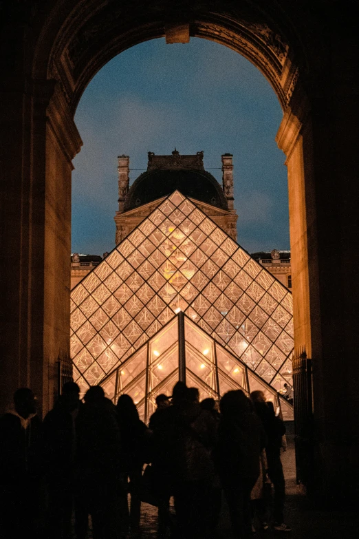 people standing outside of the entrance to an egyptian - style building