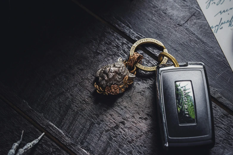 a gold ring sits next to a small cell phone