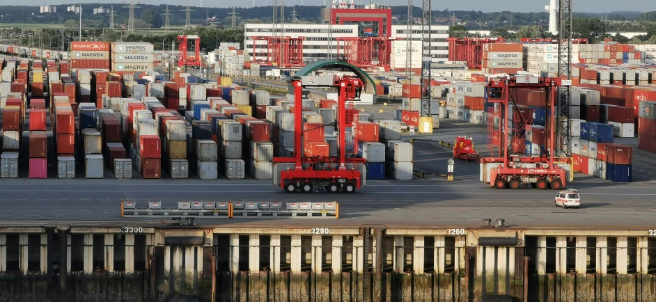 an aerial view of an open dock with a bunch of containers and vehicles