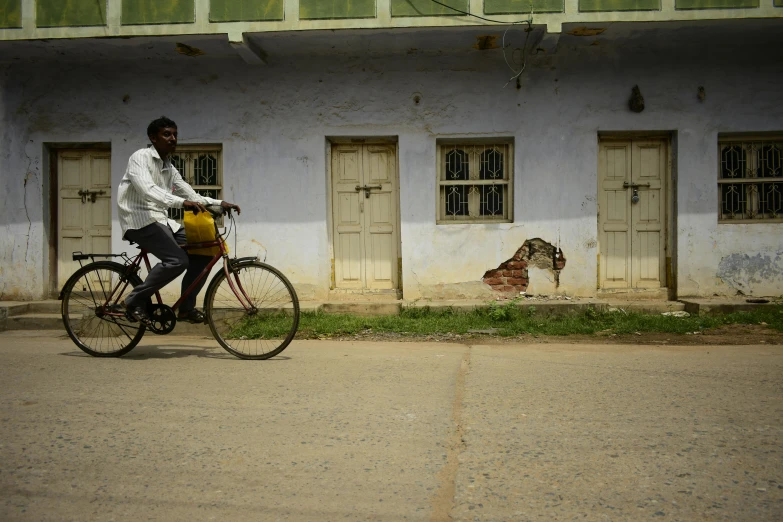 a man riding on the back of a bike down a street