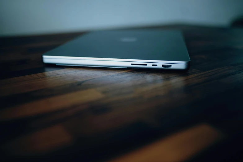 a close up of an open laptop computer on a wooden desk