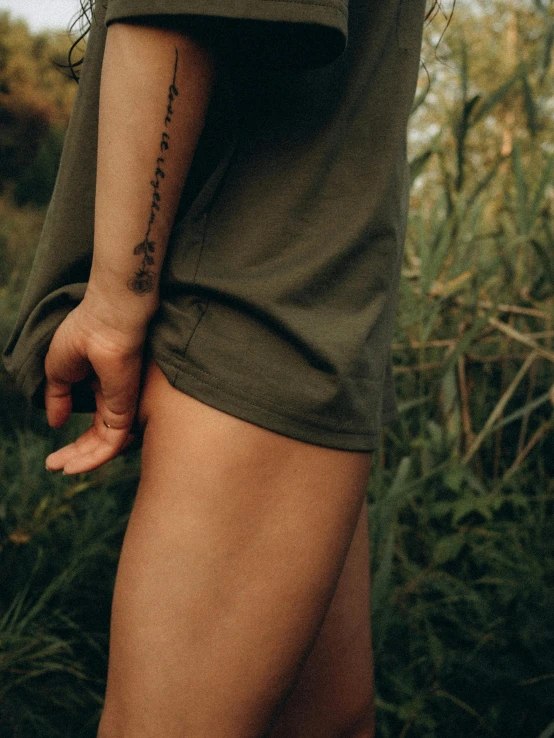 a female with a black and gray tattoo on her left arm