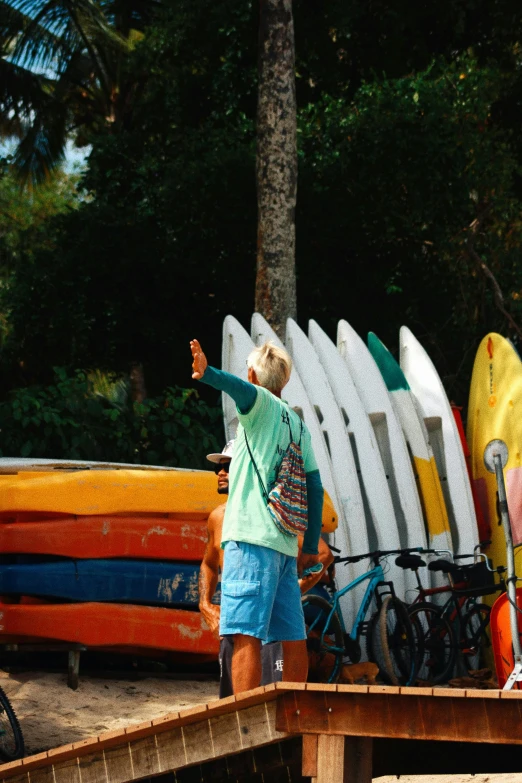 man standing on a dock with several surfboards