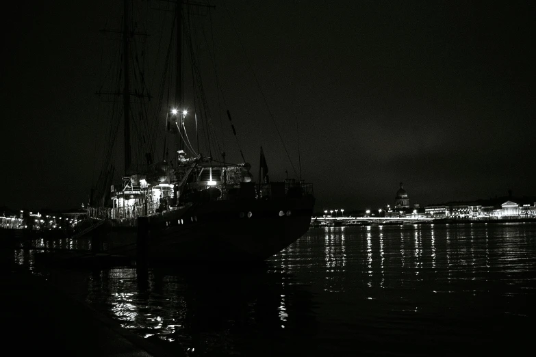 the lights on the sailboat are reflecting in the water