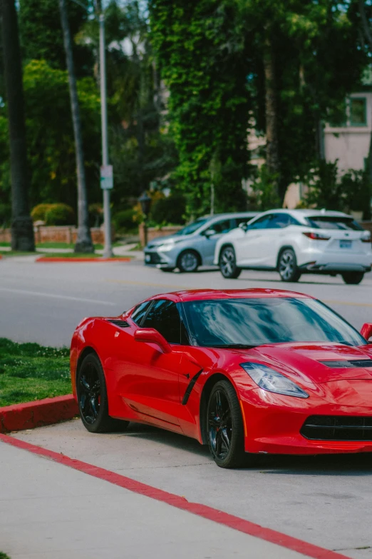 a red sports car sits parked on the curb of a residential street