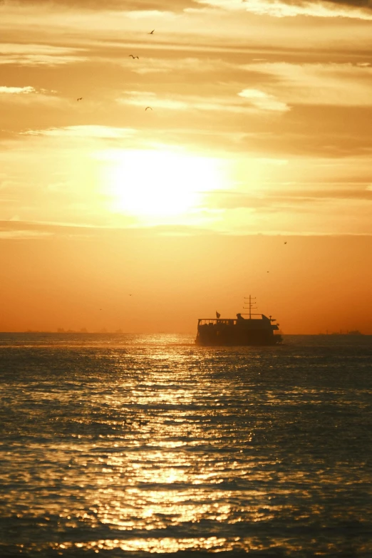 the ship travels in the sea during the sunset