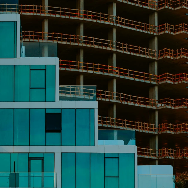 two buses driving past tall buildings with balconies on top of them