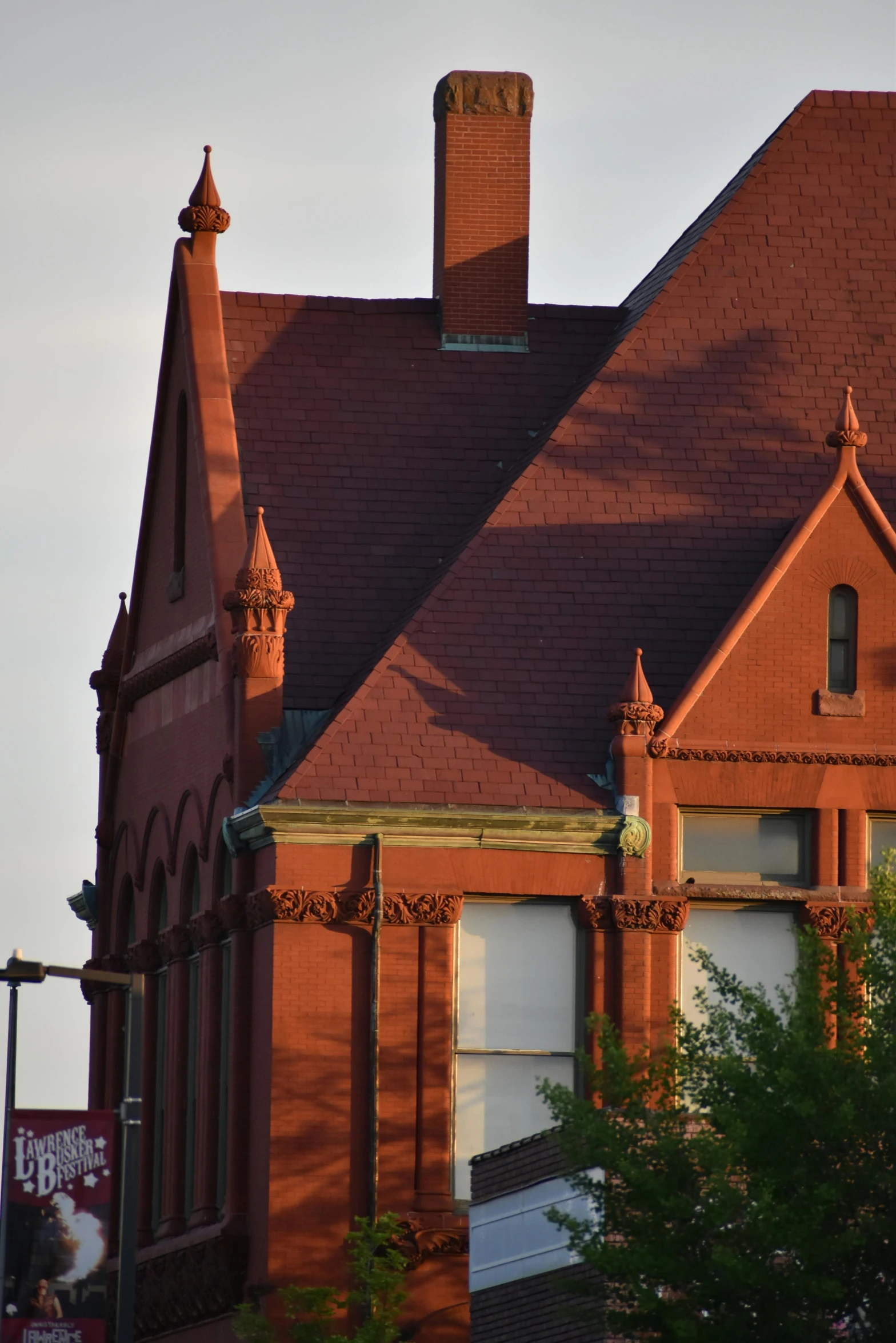 the old building with the decorative brick roof is next to a tree