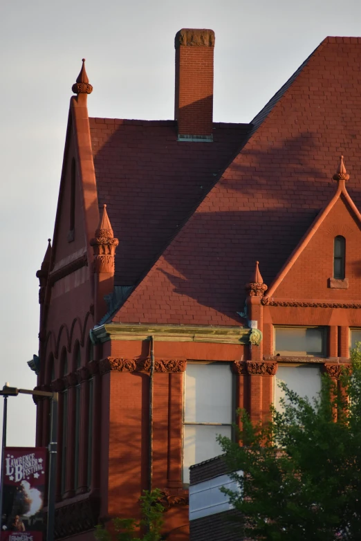 the old building with the decorative brick roof is next to a tree