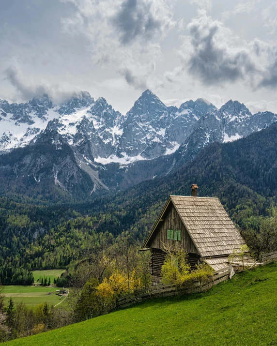 the small cabin is nestled in the grassy valley