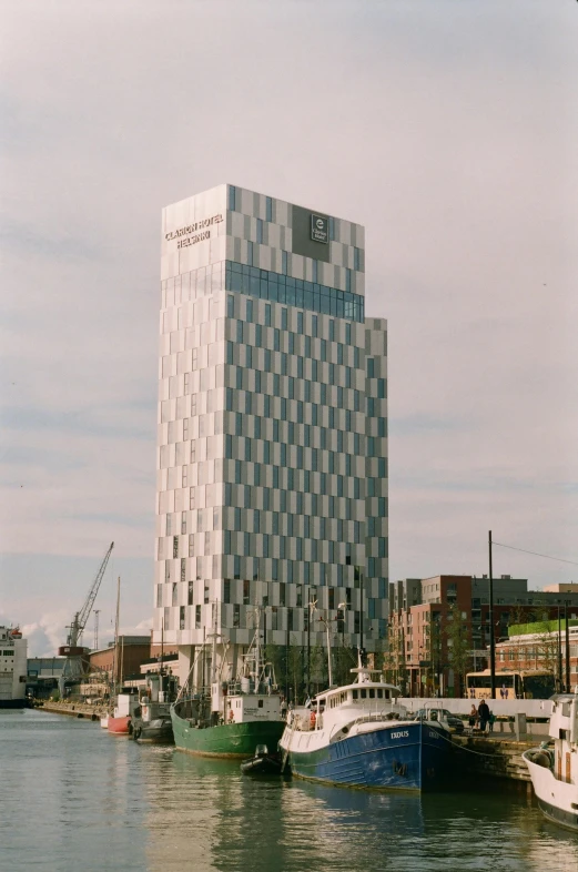 a city harbor with docked boats in it and a very tall building near by