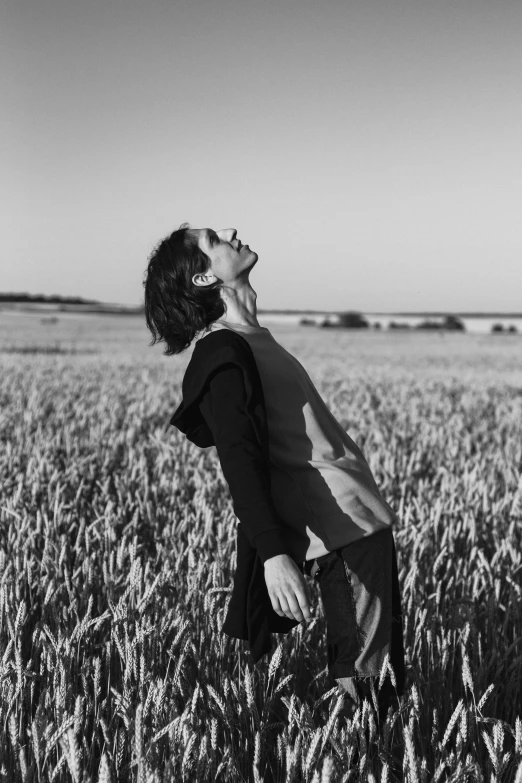 a black and white image of a man standing in a field