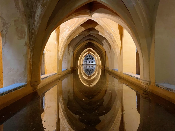 a hallway in a building that has reflection and light on the floor