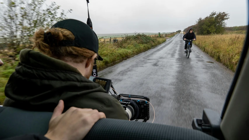 a couple riding on bikes down the middle of a dirt road