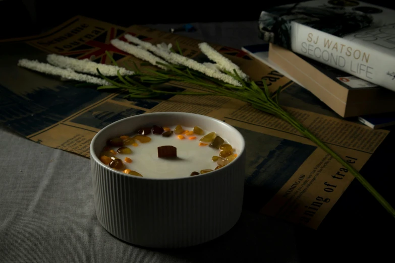 a cup of dessert is next to some books