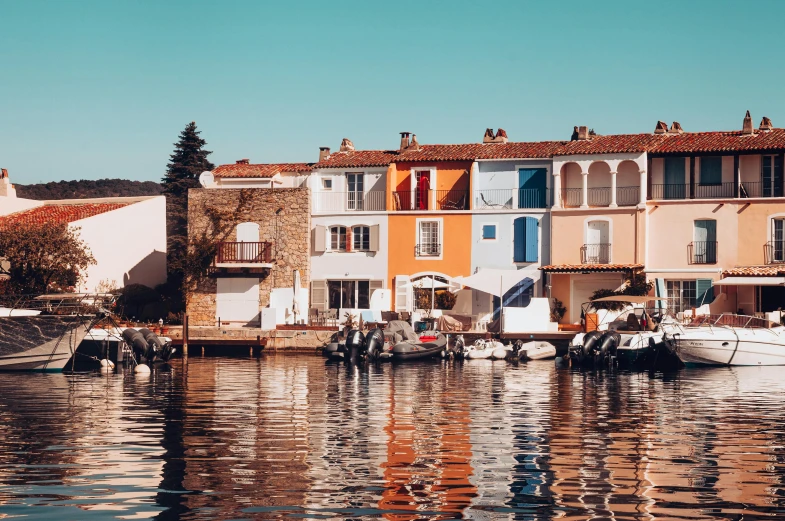 some boats are floating on the water near buildings