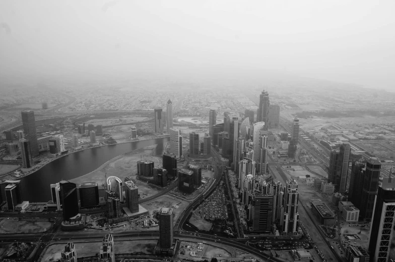 black and white image of the city skyline with cars driving through it