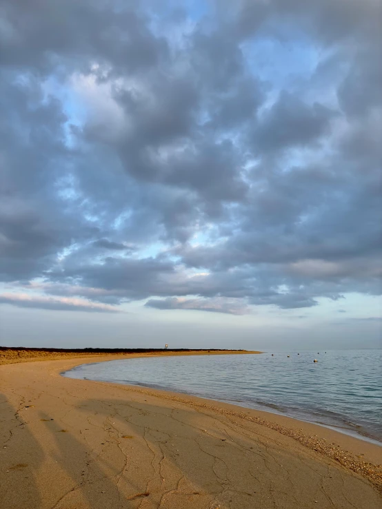 a cloudy sky over the water and beach