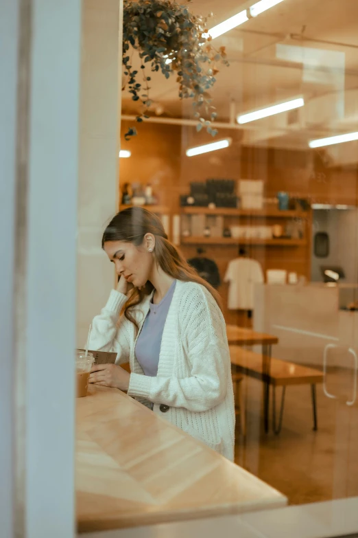 a woman at a table in front of a glass window